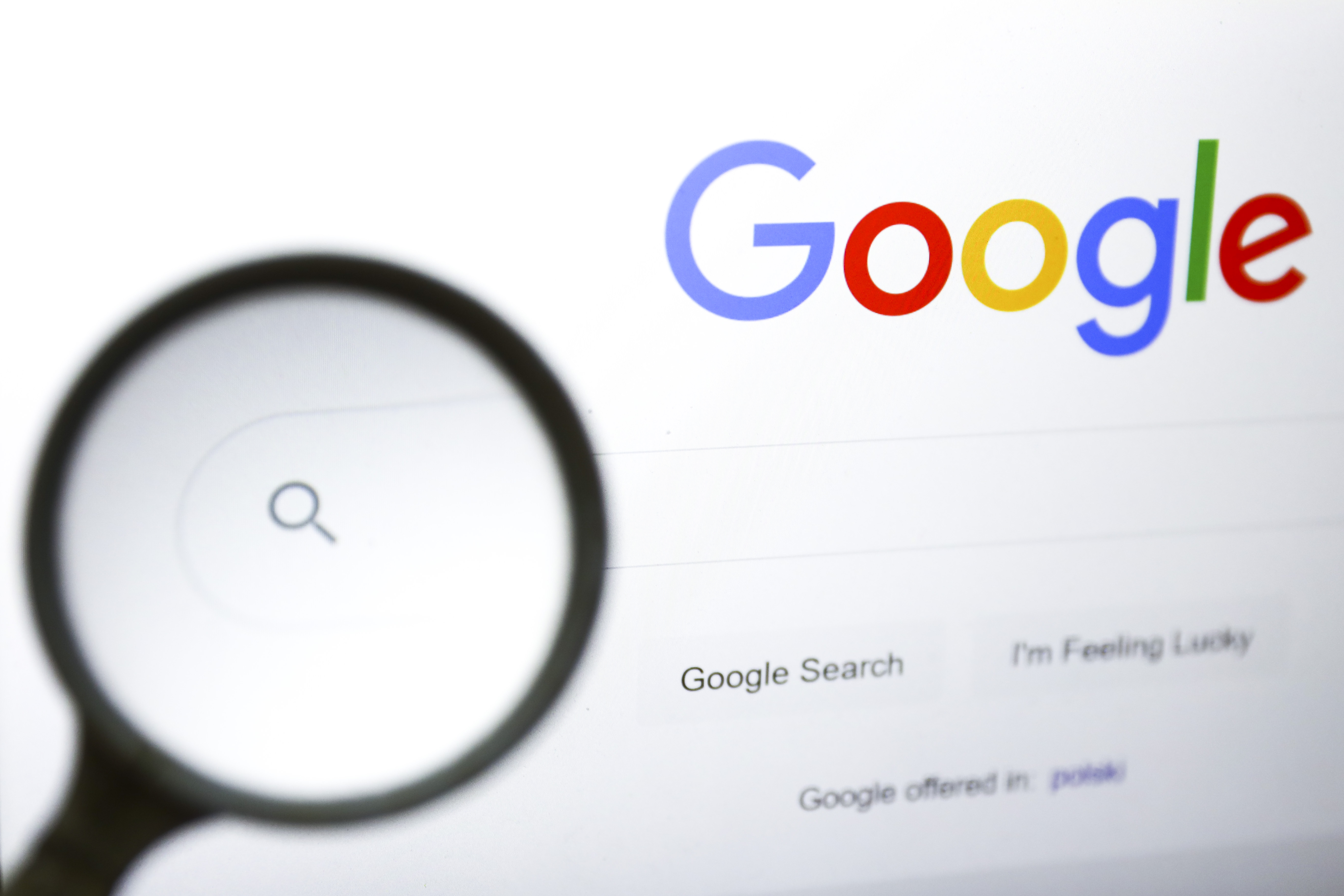 Uma lupa é fotografada com o logotipo do Google exibido na tela de um laptop. (Beata Zawrzel—NurPhoto/Getty Images)